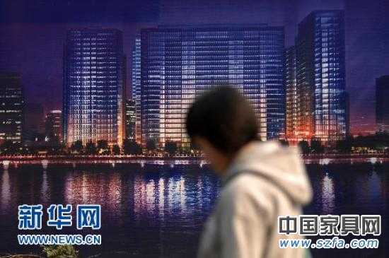 一位市民從杭州市區的一處商業樓盤廣告牌前走過（2010年11月4日攝）。新華社記者 黃宗治 攝 